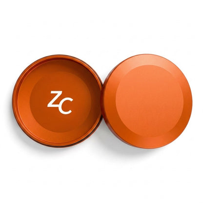Z Caddy metal pouch can in orange, lid and base shown separated from above